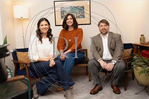 photo of the three mediators, seated in cozy office, smiling at the camera